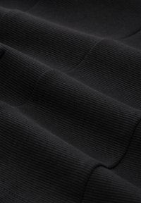 Tissu ribbed noir présentant une texture douce et un léger éclat, affichant un motif ondulé avec des profondeurs variées et des coutures lisses.