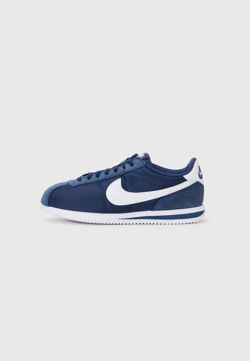 Baskets Nike bleu marine avec logo swoosh blanc, semelle blanche avec bande bleue, design à lacets et embout texturé vues de côté.