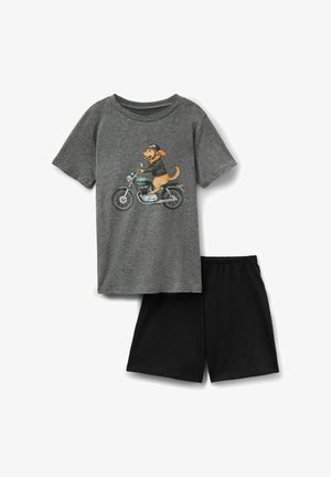 Chemise grise à manches courtes avec un chien portant un casque et une veste, conduisant une moto verte, accompagnée d'un short noir uni.