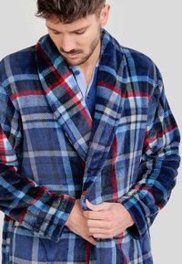 Bata de polar de cuadros con patrones en azul, rojo y negro. Cuello de chal y mangas largas, textura suave y cierre con lazo.