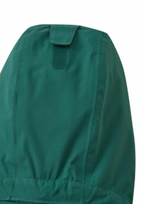 Capuche verte d'une veste, fabriquée en matériau lisse et résistant à l'eau. Comprend une fermeture à scratch à l'arrière et un bas élastique.