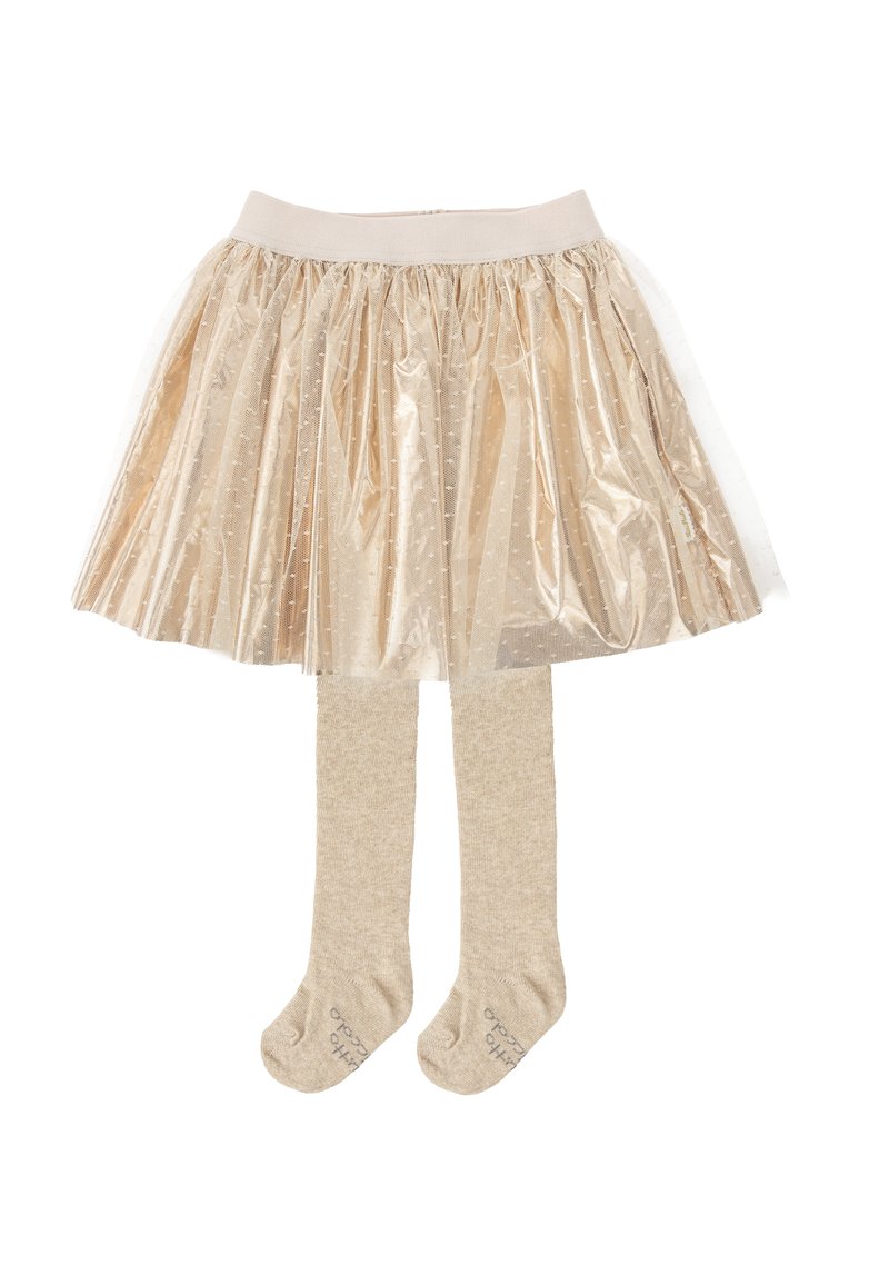 Falda de tul dorada con pliegues y capa transparente, combinada con medias nude. La falda cuenta con una suave cinturilla elástica y un patrón de puntos.