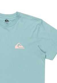 Light blue short-sleeve t-shirt made of cotton, featuring a small pink logo on the left chest area. Soft texture and standard fit.