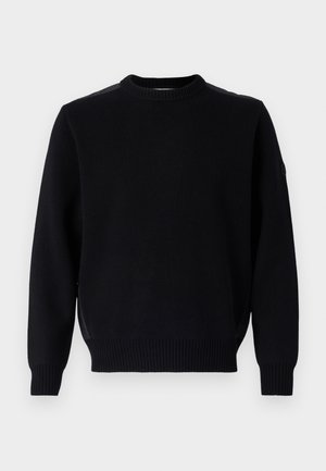 Fekete kötött pulóver kerek nyakkal, bordás mandzsettákkal és aljjal. Oldalhasítékokkal és egy kis logóval rendelkezik az ujjon.