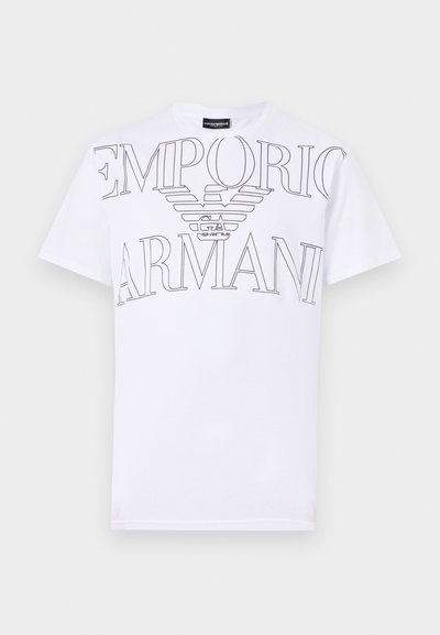 T-shirt en coton blanc arborant un grand logo noir Emporio Armani avec un design d'ailes. Manches courtes et col rond classique.