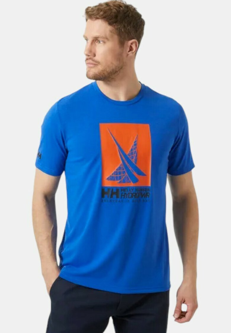 Camiseta azul de manga corta hecha de una tela suave, con un diseño gráfico naranja y texto negro en la parte frontal, con una marca en la manga.