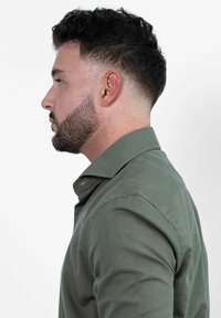Olijfgroene shirt met een button-down kraag, met een slim fit ontwerp. De stof lijkt soepel en benadrukt een gestroomlijnde silhouet.