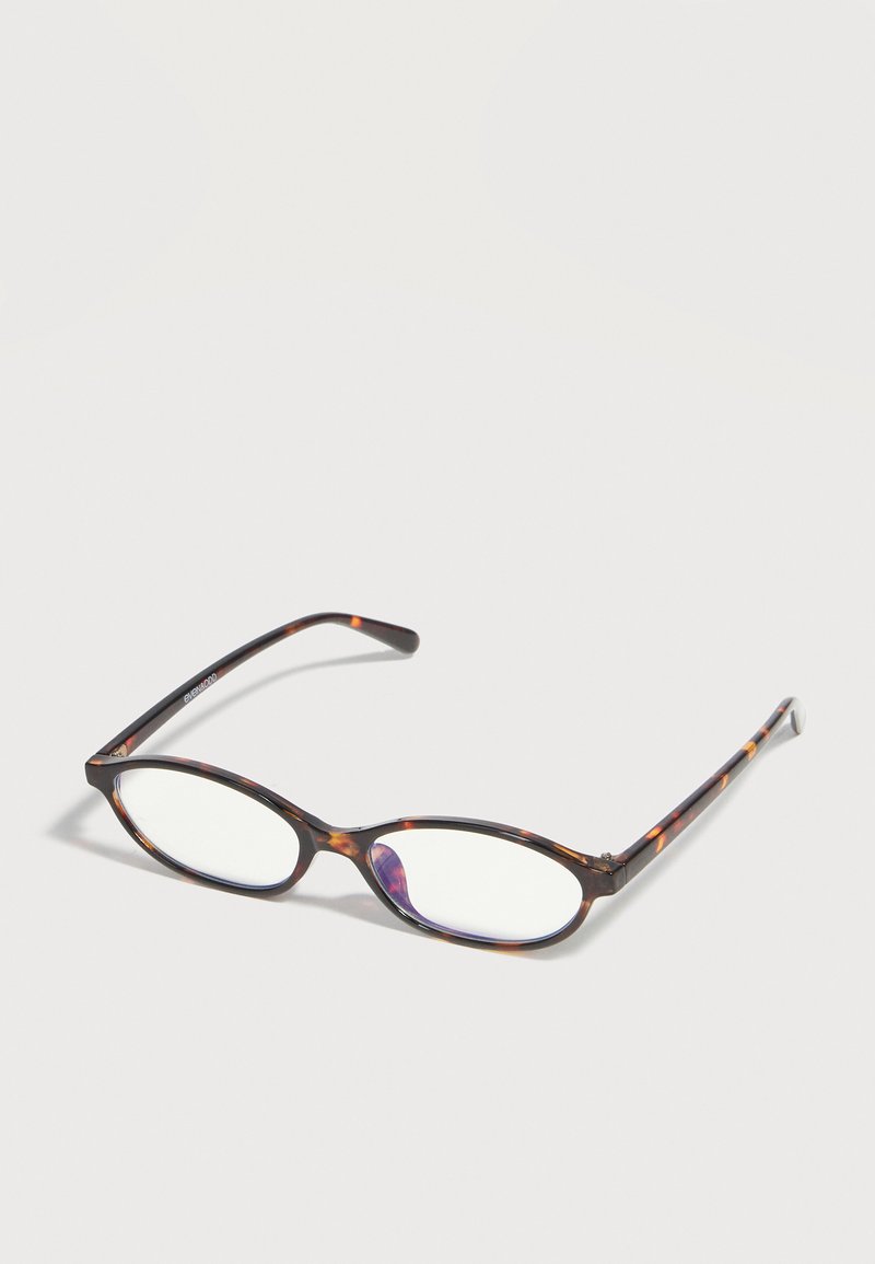 Rechteckige Schildpatt-Brille mit dünnem Gestell und klaren Gläsern, die auf einer hellen Oberfläche liegt.