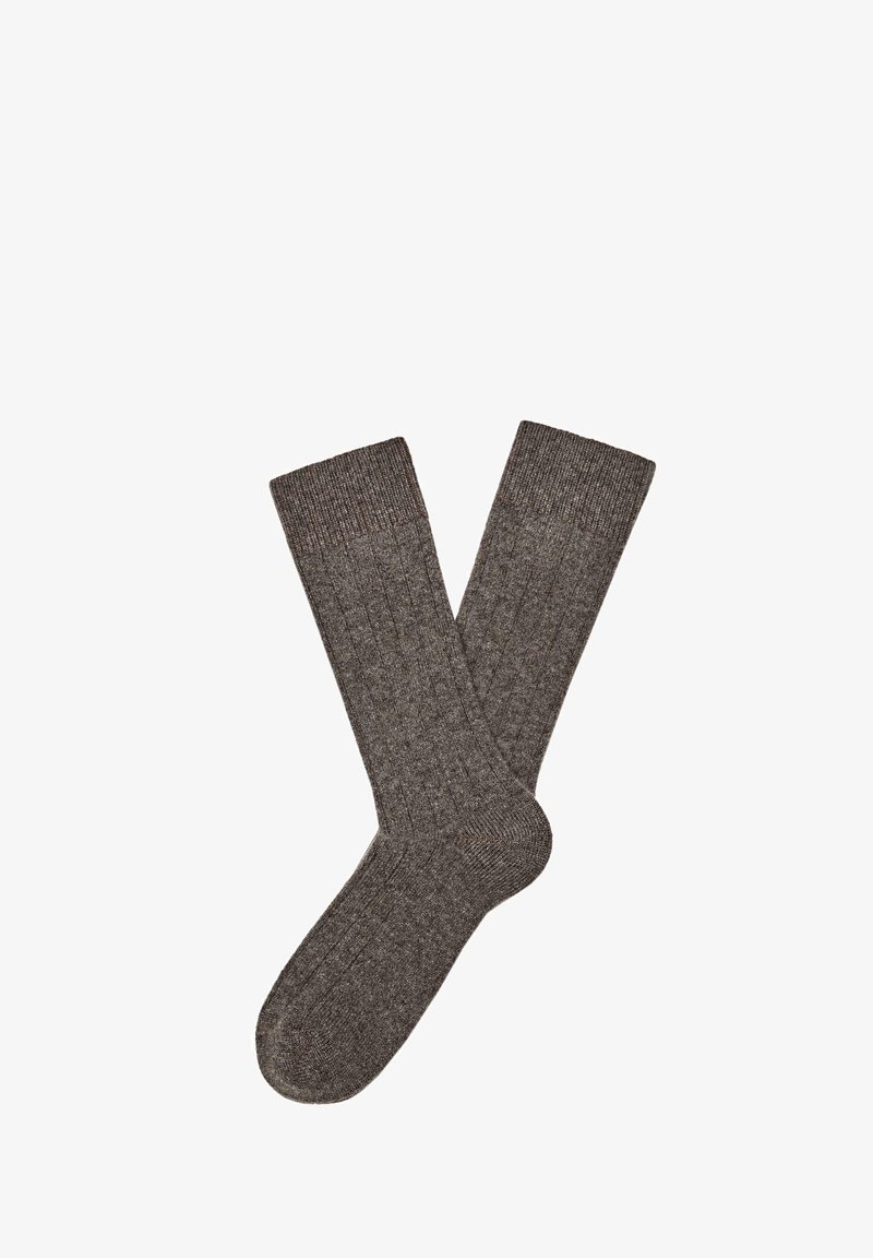 Bruine geribbelde sokken gemaakt van gestructureerd materiaal. Ze hebben een effen kleur met een patroon langs de lengte en een contrasterende boord.