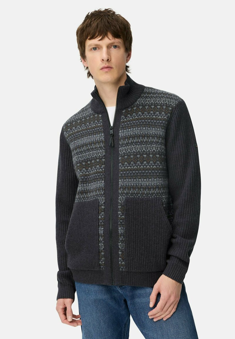Grijze gebreide zip-up trui met geribbelde structuur, een patronen yoke in donkergrijs en blauwe tinten, en twee voortassen.