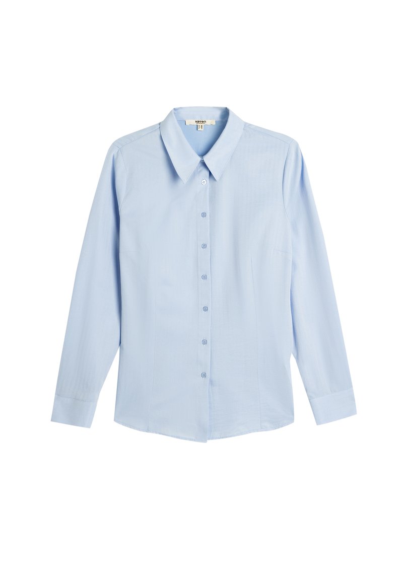 Camisa de botones de manga larga de color azul claro, con cuello, corte recto y una textura sutil. Presenta una tapeta delantera y un bolsillo en el pecho.