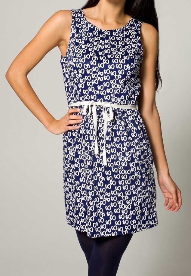 Abito senza maniche di colore blu navy con un motivo astratto bianco, busto aderente, vita cincherata con un nastro e gonna svasata. Tessuto con texture liscia.