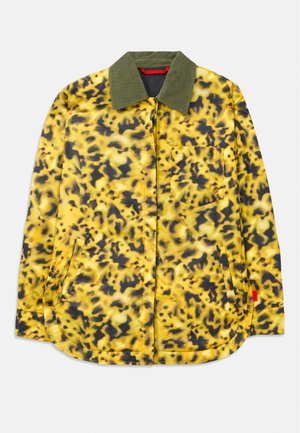 Gelb und schwarz gemusterte Jacke mit grünem Kragen, ausgestattet mit einer Fronttasche und zwei Seitentaschen; glattes Material und geschwungener Saum.