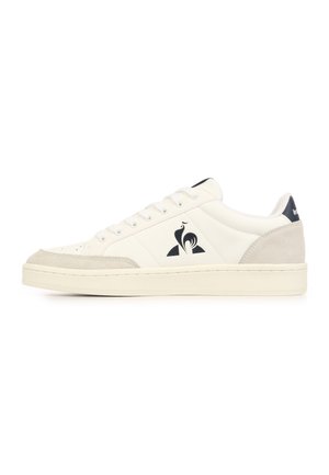 Baskets basses blanches avec des accents en daim sur l'avant et le talon, design à lacets et logo coq noir sur la face latérale.