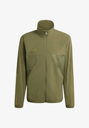 Chaqueta verde oliva con cremallera, cuello alto, dos bolsillos delanteros y sutiles elementos de diseño triangulares. Fabricada con una tela suave y ligera.