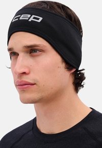 Zwarte elastische sporthoofdband met het "cep"-logo in zilver, sluit nauw aan, heeft een gestructureerd materiaal en is ontworpen voor comfort tijdens fysieke activiteiten.