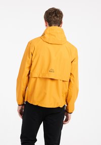 Žltá nepremokavá bunda s kapucňou, elastickými manžetami a ventilačným klapkou na chrbte, s logom na krku.