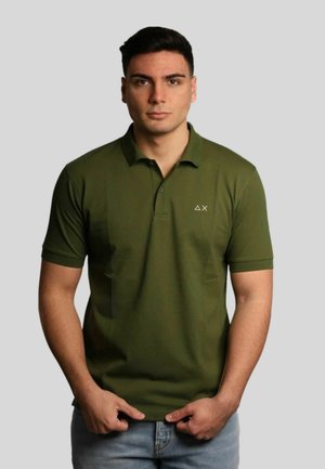 Polo shirt verde oliva con maniche corte e colletto a tre bottoni. Presenta un piccolo e discreto logo sul lato sinistro del petto. Texture liscia.