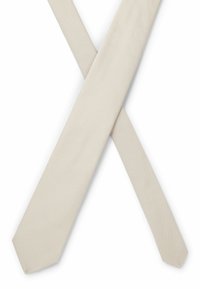 Cravate beige avec un design en tissu texturé, présentant une finition lisse et une pointe effilée, disposée en forme de X superposé.
