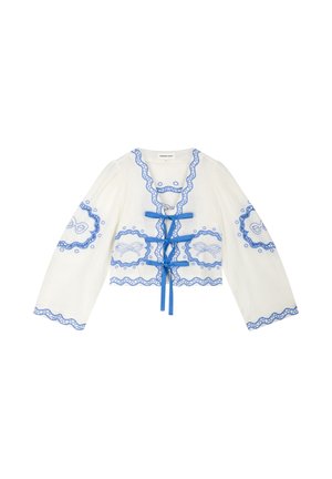 White long-sleeve blouse with blue scalloped trim, embroidered floral patterns, and three blue ribbon ties down the front.