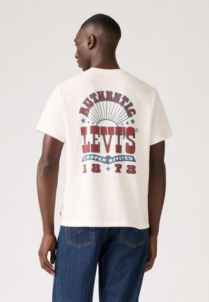 Camiseta de algodón blanca con un gráfico retro en rojo y azul en la parte posterior que dice "AUTHENTIC LEVI'S® COPPER RIVETED 1873." Corte relajado.