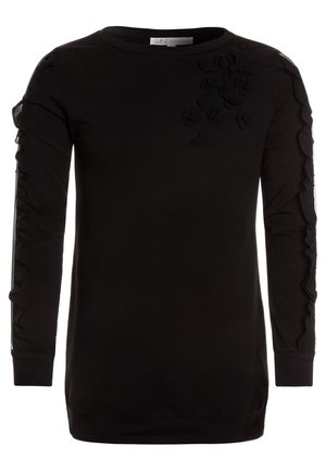 Chemise noire à manches longues avec des applications florales en relief sur le haut de la poitrine et le long des manches.