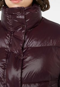 Bordeauxfarbene Daunenjacke mit hohem Kragen, glänzender Textur und Druckknöpfen. Verfügt über ein gestepptes Design zur Isolierung und einer eleganten Oberfläche.