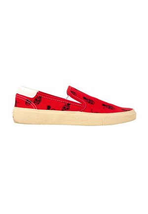 Baskets rouges à enfiler avec imprimé crâne noir et ananas, languette blanche au talon et semelle en caoutchouc beige texturée.