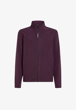 Lilla fleecejakke med høj krave og fuld frontlynlås. Har lange ærmer og et logo på venstre ærme. Glat tekstur.