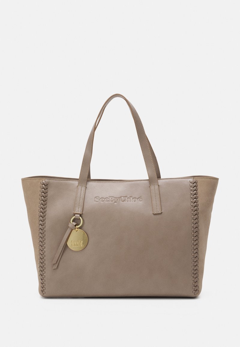 Taupe læder tote taske med fletdetalje på den ene side, præget logo foran og en guldrund charme fastgjort til et rem.