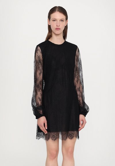 Rochie din dantelă neagră cu mâneci lungi transparente, decolteu rotund și tiv ondulat. Textura este complexă, cu modele florale.