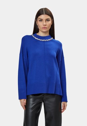 Pull oversized bleu avec un col rond, comportant un détail décoratif en gemme au col, fabriqué à partir d'un matériau tricoté doux.