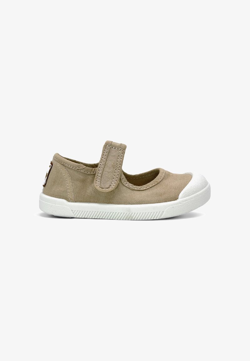 Chaussure pour enfant en toile beige avec semelle en caoutchouc blanche et bout renforcé, dotée d'une sangle unique à fermeture Velcro sur le dessus.