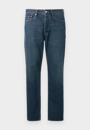 Jeans de ganga azul escuro com um corte de perna reta, cinco bolsos e costuras visíveis. Possuem um botão metálico e fecho de correr.