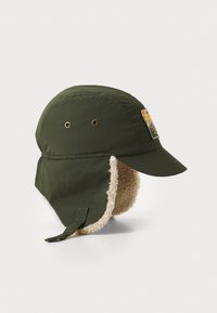 Oliven grønn hatt med skjerm, myke fleeceøreflapper, metalløyler og en lapp med et geometrisk design i oransje og gult.