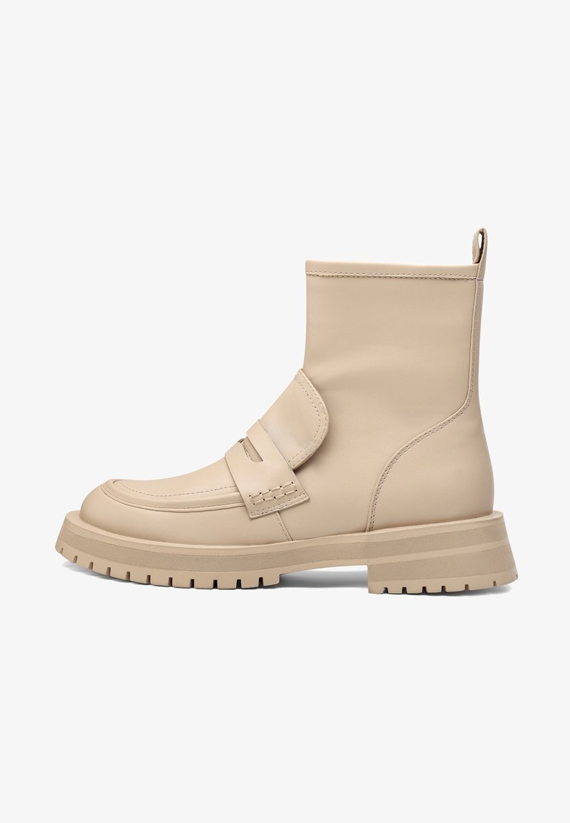 Botines de cuero beige hasta el tobillo con suela plana, que cuentan con una cinta ancha en la parte delantera y un acento texturizado. Lengüeta en la parte posterior para facilitar su colocación.