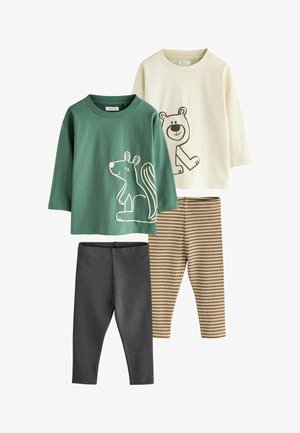 Twee jonge jongens glimlachen, dragen dierenprint lange mouwen shirts en leggings, lopend op een lichte neutrale achtergrond.