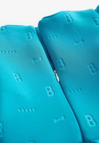 Tyrkysová bunda na zips s embosovanými písmenami "B" a "BAKER," so zlatým ťahátkom na zips a hladkým, štruktúrovaným materiálom.