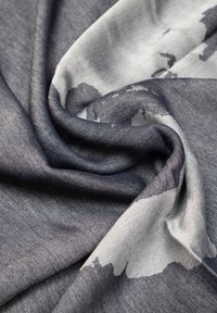 Tessuto leggero in tonalità di grigio, con un delicato motivo astratto. Texture con una finitura liscia, elegantemente drappeggiato.