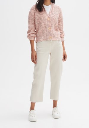 Cardigan rosa, lavorato a maglia, con scollatura a V e tre bottoni, abbinato a pantaloni cropped beige chiaro e sneakers bianche. Texture liscia, vestibilità rilassata.