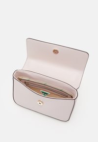 Ljusrosa plånbok av texturerat läder med guldig tryckknappslås, utrustad med ett inre blixtlåsfack och en triangel-logotypdetalj.