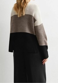 Stickad tröja med en avslappnad passform, med färgblockerade sektioner i kräm, taupe och svart. Texturerat tyg med långa ärmar.