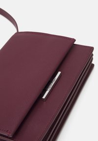 Calvin Klein LINEAR CROSSBODY - Pochette - oxblood