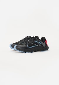 Zwarte sportschoenen met mesh-details, blauwe accenten en een dikke zool. De hak heeft een ontwerp in rood en grijs.