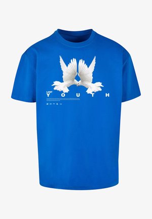 T-shirt en coton bleu arborant un graphisme de deux colombes blanches aux ailes déployées, avec le texte "JEUNESSE PERDUE" en lettres majuscules en dessous.