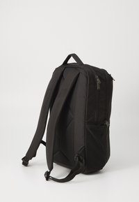 Zaino nero con spallacci imbottiti, maniglia superiore e numerosi scomparti con zip. Presenta un materiale testurizzato e una forma rettangolare elegante.