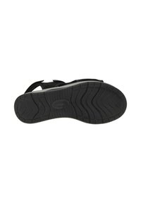 Zwarte sandaal met een gestructureerde rubberen zool met flexibele groeven, verstelbare banden en een zachte voetbed voor comfort.