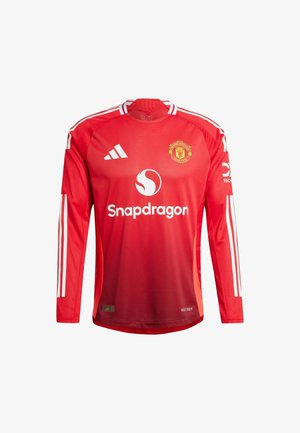 Rode longsleeve trui van lichtgewicht materiaal, met witte strepen op de schouders, een ronde hals en het Manchester United-logo op de borst.