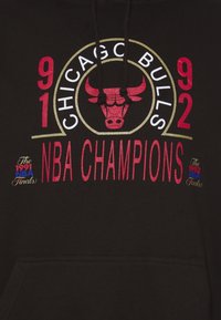 Logo des Chicago Bulls avec « 1991 1992 NBA Champions » et références aux Finales NBA sur un tissu noir, probablement sur le devant d'un sweat à capuche.