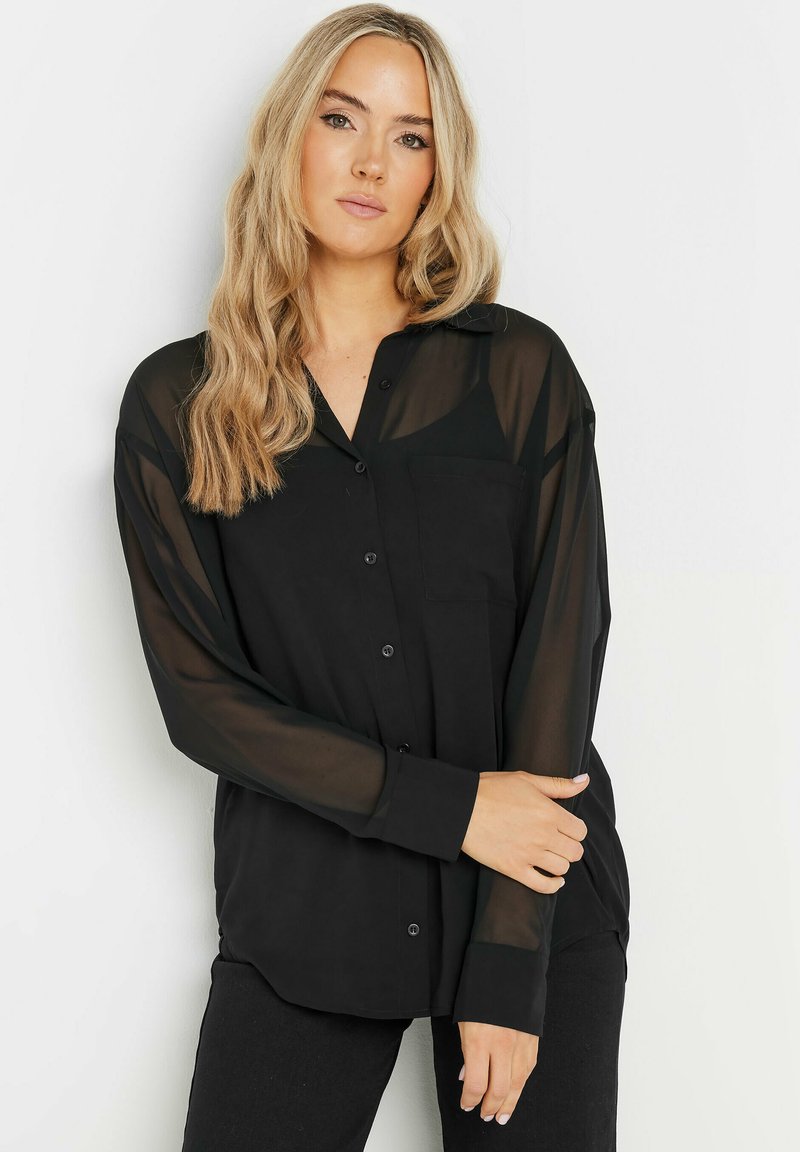 Camicia nera trasparente a maniche lunghe con bottoni frontali, taschino sul petto e fit rilassato. Tessuto liscio e leggero.